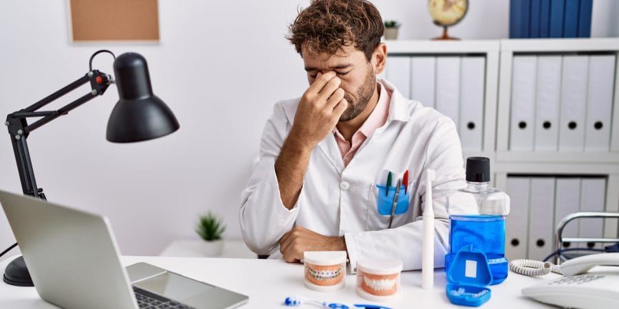 dentiste seul dans son cabinet qui semble angoissé